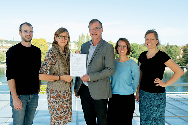 Gruppenfoto der Vertreterinnen und Vertreter der Gebhardschule und der HTWG auf der Dachterrasse der Hochschule. Im Hintergrund der Seerhein in Konstanz