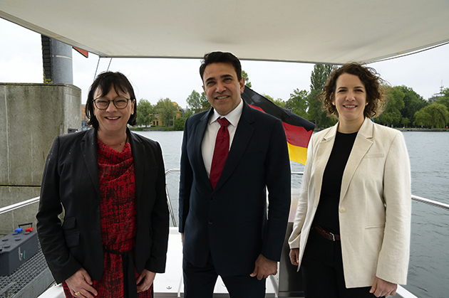 Das Bild zeigt Sabine Rein, Mohit Yadav und Lina Seitzl auf dem Forschungsboot Solgenia. Im Hintergrund ist der Seerhein sowie die Deutschlandfahne, die das Schiff trägt, zu sehen.