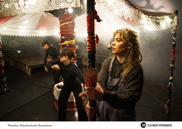 Drei junge Frauen auf der Drehbühne beziehungsweise auf dem Karrussel. Nebel umhüllt die drei Schauspielerinnen, was eine düstere Atmosphäre bewirkt.