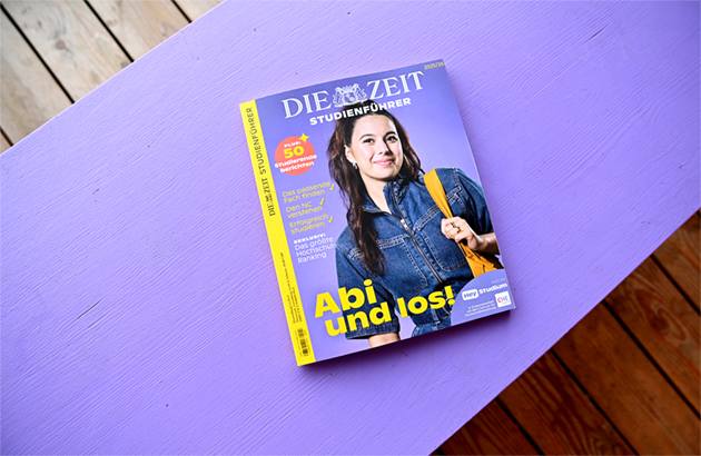 Der Zeitstudienführer liegt auf einer lilafarbenen Holzfläche