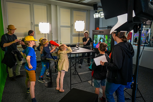 Mehrere Kinder und Erwachsene drehen eigene Videos im Studio