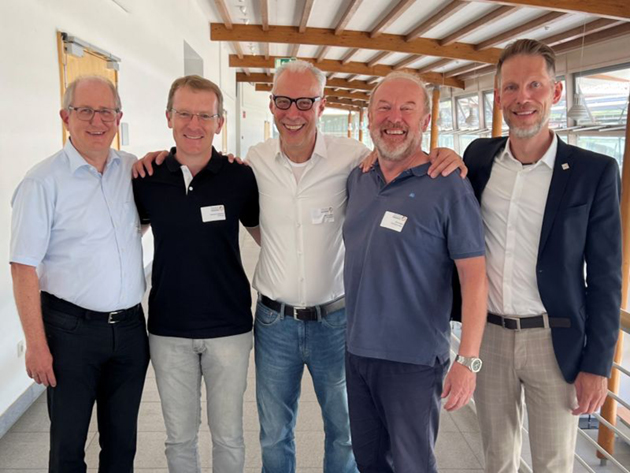 Fünf Männer lachen freundlich in die Kamera