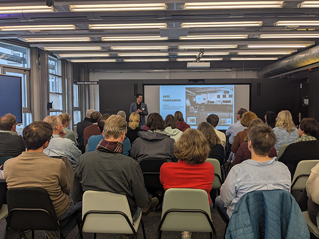 Ein Mann stellt vor einem Publikum ein Projekt vor 