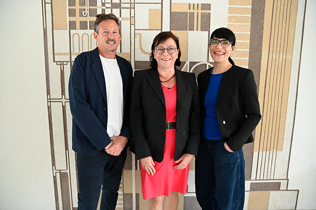 W4-Co-Geschäftsführer Markus Rhomberg, HTWG-Präsidentin und W4-Vorsitzende Prof. Dr. Sabine Rein und W4-Co-Geschäftsführerin Alexandra Hassler lächeln in die Kamera, im Hintergrund eine Wand einem Gemälde