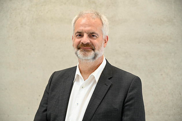 Portrait von HTWG-Kanzler Manfred Schnell vor beige-grauem Hintergrund
