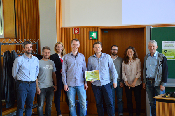 Acht Menschen posieren in einem Raum der HTWG für ein Gruppenfoto.