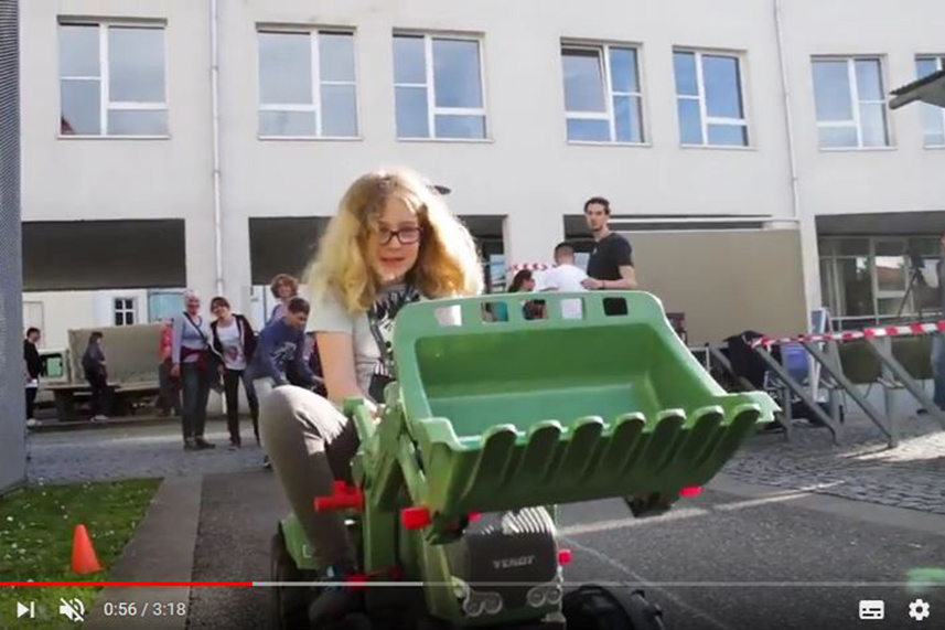 Screenshot aus dem Video zum eMobility-Projekt: Ein Mädchen sitzt auf einem Modelltraktor.