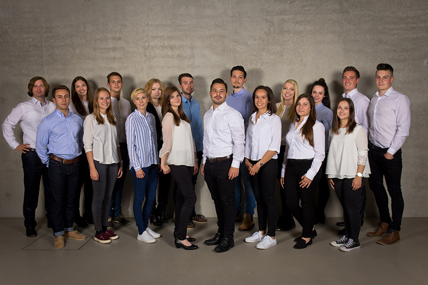 Gruppenfoto von jungen Menschen in Geschäftskleidung.