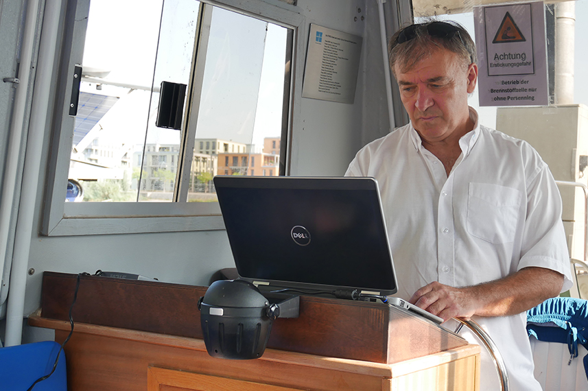 Laboringenieur Dr. Alexander Kirjuchin steht vor einem Laptop im Führerhaus der Solgenia. 