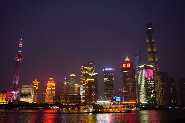 Die hell erleuchteten Gebäude der Finanzmetropole von Shanghai bei Nacht.