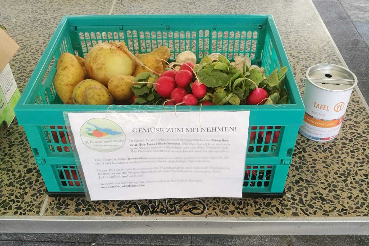 Eine Kiste voller Gemüse steht auf einer Tischtennisplatte.