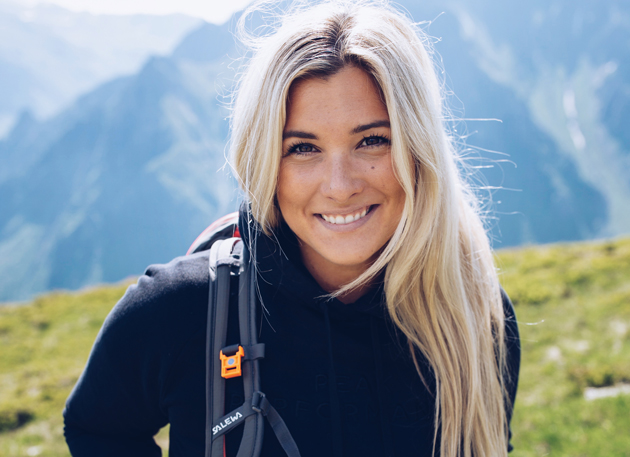 Portrait von Linda Meixner inmitten einer Berglandschaft.