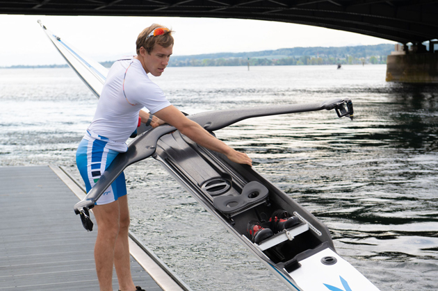 Der Ruderer Florian Roller lässt im Sportdress sein Ruderboot ins Wasser.