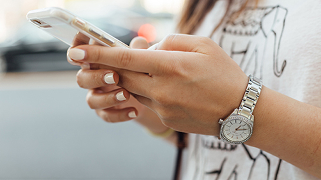 Zu sehen sind zwei Hände, die ein Smartphone umfassen.