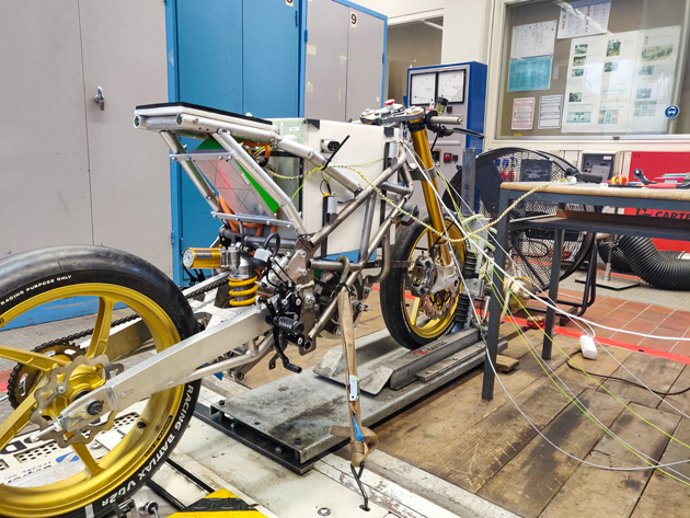 Ein Motorrad steht in einer Werkstatt auf dem Rollenprüfstand.
