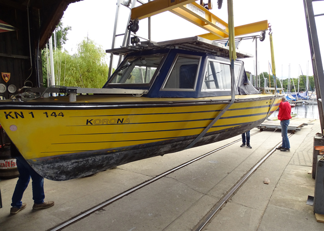 Das Solarboot Korona wird von einem Kran in eine Halle gezogen.