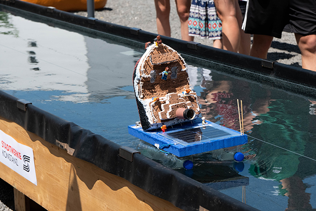 Das Foto zeigt ein selbstgebautes Solarboot, das im Wasserbecken fährt. 