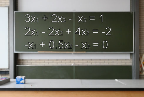 Ein Gleichungssystem auf einer Schultafel.