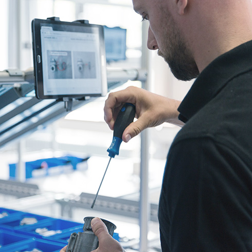 Student working with a screwdriver in HTWG´s model factory