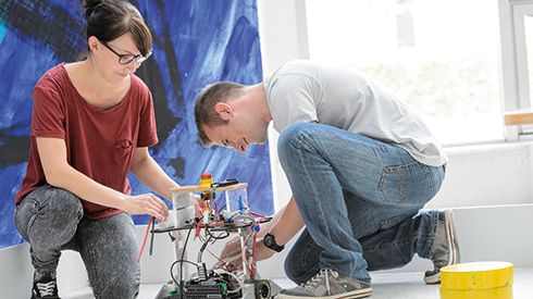 Zwei Studierende führen gemeinsam ein Experiment durch