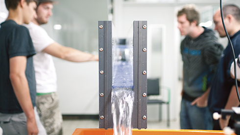 Students around a water model in the hydraulic engineering laboratory 