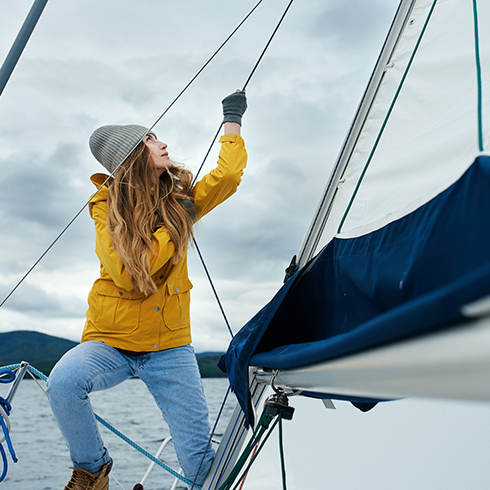 Young woman sailing on a sail boat.