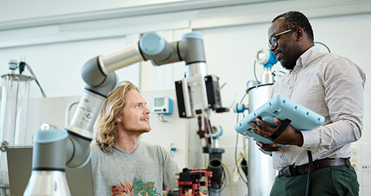 Student und Dozent mit Roboterarm 