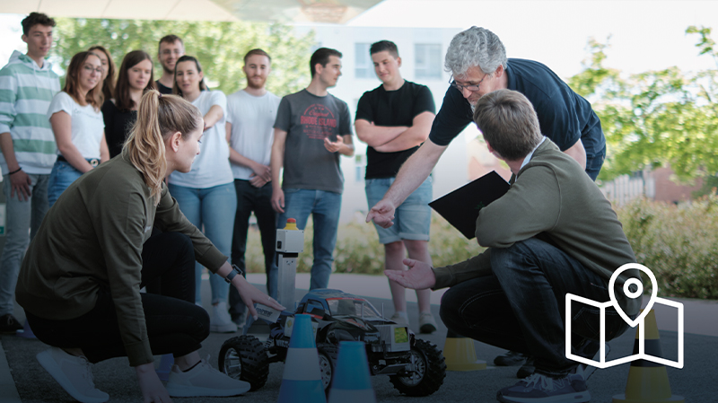 Schüler beobachten einen Testlauf eines Elektroautos